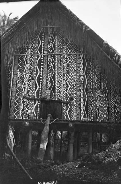 Temple on stilts with intricately painted facade and lizard sculpture