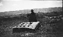 Man standing near shaped monoliths in valley