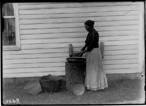 Seneca woman sifting corn meal