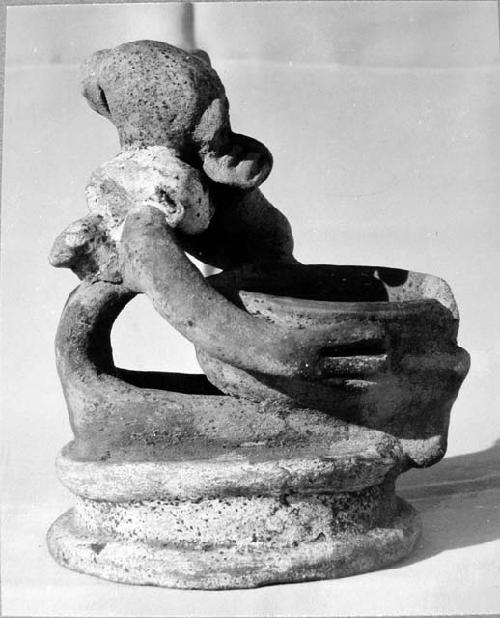 Pot 17, Grave 2. Pottery figure seated on low platform holding a small bowl