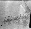 Men sailing a double outrigger dugout canoe
