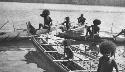 Men rowing a double outrigger dugout canoe