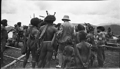 Rear view of men wearing feathers, nose rings, earrings