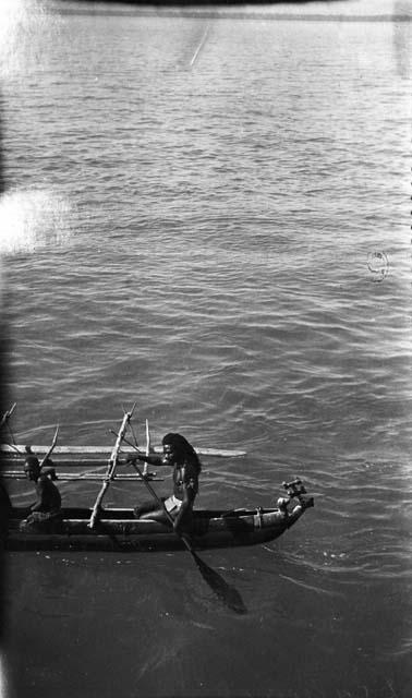 Men rowing dugout canoes