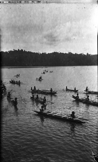 Men rowing double outrigger dugout canoes