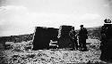 Group standing in front of large man arranged monoliths in valley