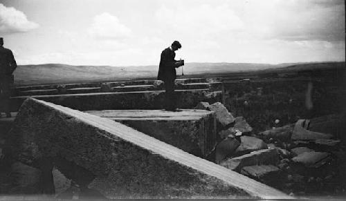 Man standing on large, shaped monoliths in valley