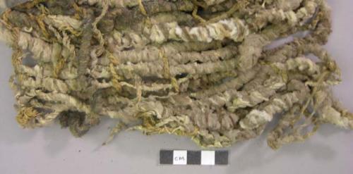 Animal hide with fur, twisted into strands with fiber twine fragments