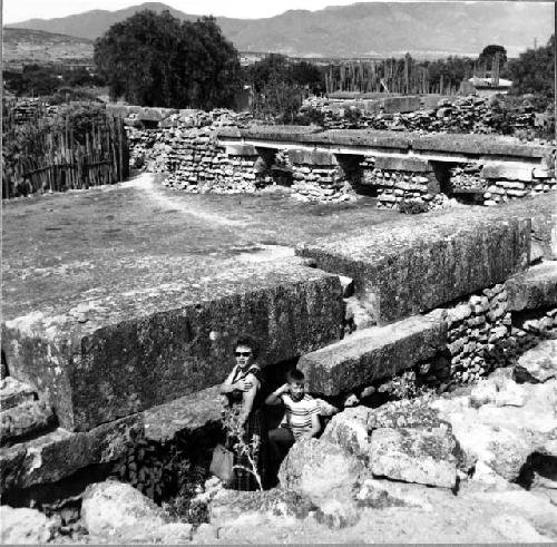 Woman and Child standing by masonry in the arroyo group at Mita