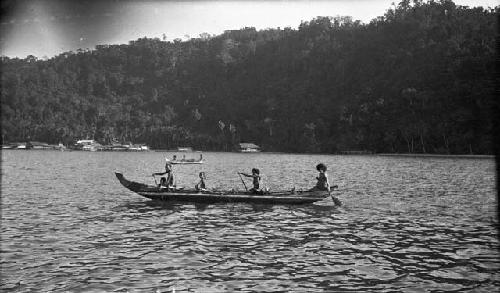 Men rowing a double outrigger dugout canoe