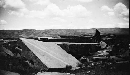 Man standing on large, shaped monoliths in valley