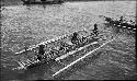 Men rowing a double outrigger dugout canoe