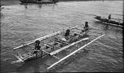 Men rowing a double outrigger dugout canoe