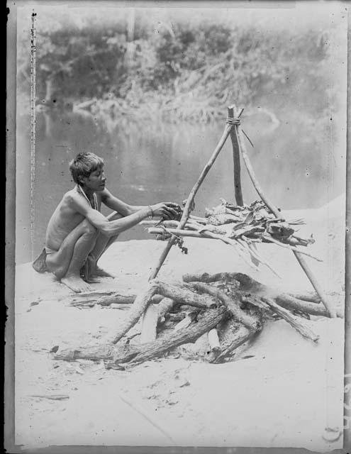 Man barbicoating (roasting) fish on the "Acori legs"