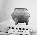 Tripodal pottery jar. Outset, stub feet. Round base, knobbed, out-turned lip. 2