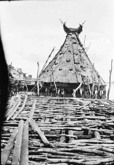 Triangular hut with sideways crescent moon shape on top.