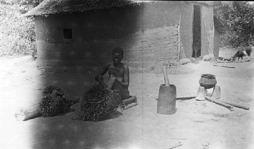 Woman cutting nuts from bunches in preparation for extracting oil