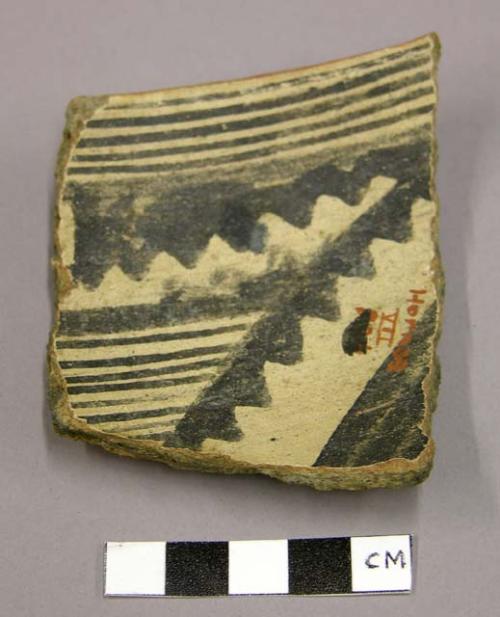 Sherd of medium sized eating bowl, with black decoration on white slip ground