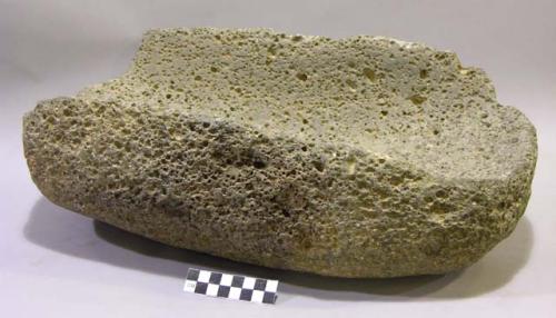 Metate. deep, open ended trough metate. rounded sides & base. ground vesicular