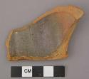 Undecorated lead glazed redware body sherd with possible handle attachment