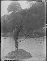 Man shooting fish with bow and arrow