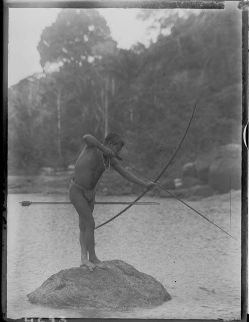 Man shooting fish with bow and arrow
