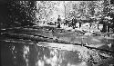 Group gathered near stream awaiting fish