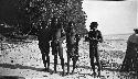 Four men on beach with weapons