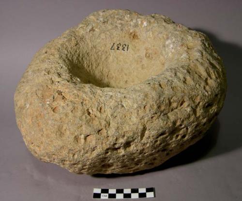 Mortar. circular boulder with large circular depression (14.5 x 4.5 cm.) in cent