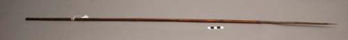 Spear, 43.5 in. l, bone tip, top of shaft carved; filled with red clay. cf. 6004