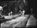 Men on two boats in river