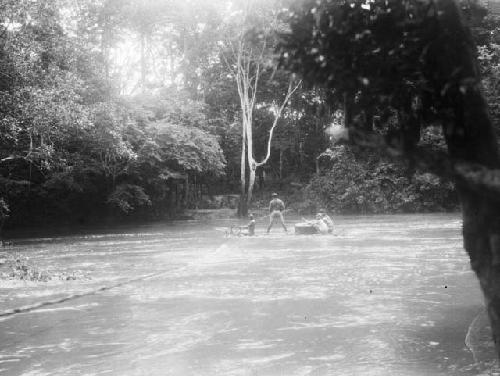 Men crossing river using rope