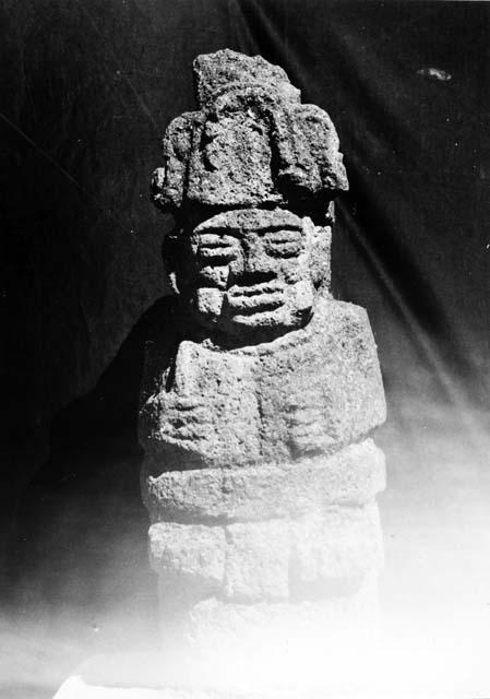 Pedestal sculpture of seated human figure