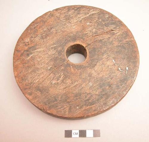 Unclassified tool, carved wood disc, hole in center, splits