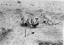 4 men seated, excavations at Pachacamac