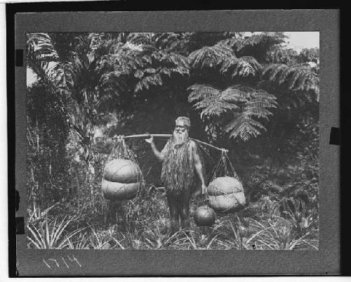 Islander with carrying pole and vessels