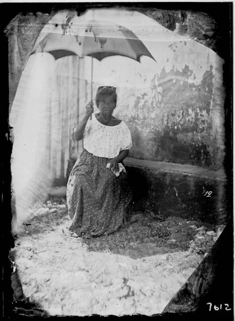 Woman sitting, holding an umbrella