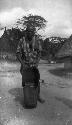 Warrior with hunting bag standing on road in village