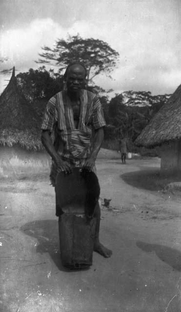 Warrior with hunting bag standing on road in village