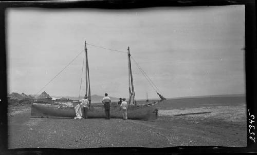 Men fixing boat in rural setting