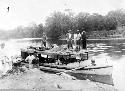 Men standing on boat and river bank