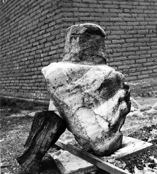 Stone sculpture of large seated pot-bellied figure