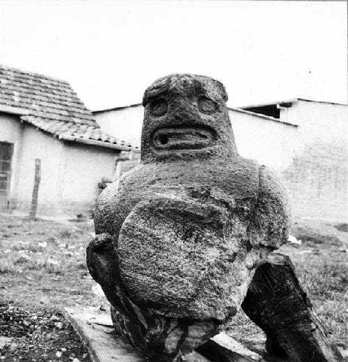 Stone sculpture of large seated pot-bellied figure