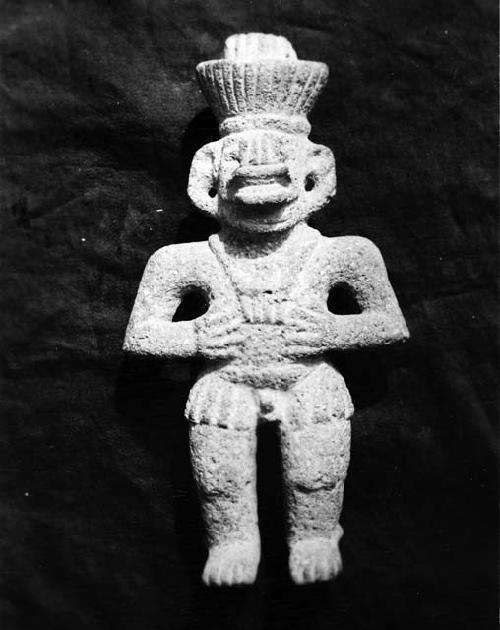 Small stone sculpture of human figure wearing mask