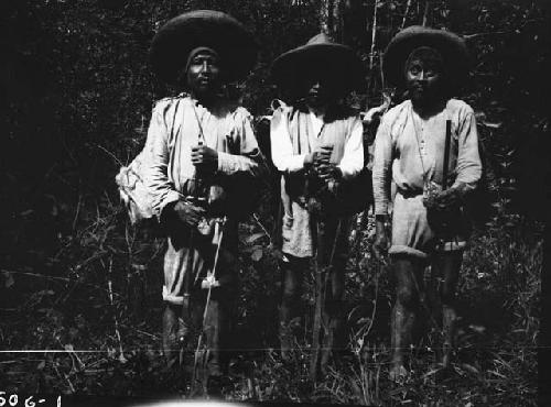 Three men in woods with tools