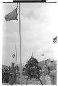 Soldier raising U.N. flag alongside wreath