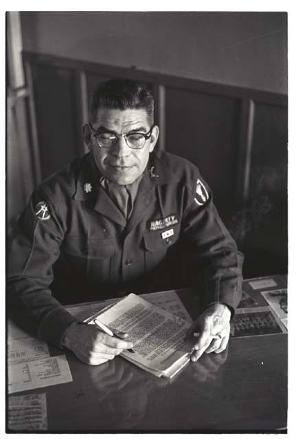 Portrait of Colonel Hagerty reviewing documents