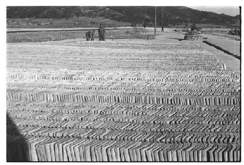 Two men standing in lot of bulding material