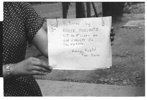 Woman holding sign Pictures by Roger Marshutz 117 So Fuller Ave Los Angeles·