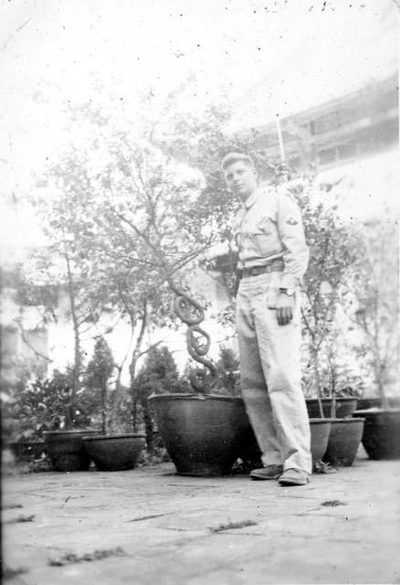 Man posing with potted trees